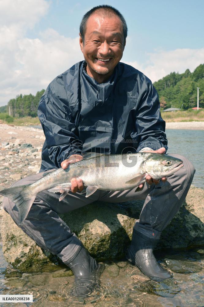 Man shows off salmon caught with net