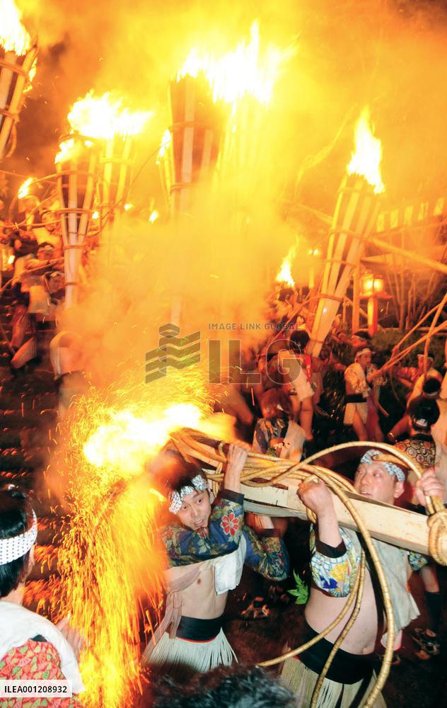 Young men swing huge torches at Kyoto fire festival