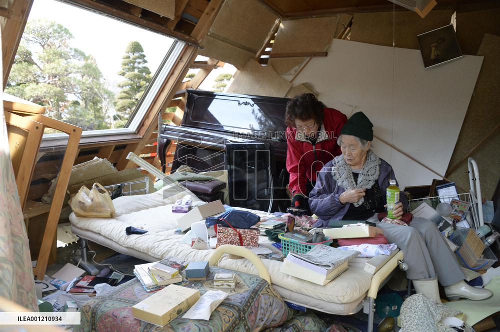 Quake-hit people clean up damaged houses