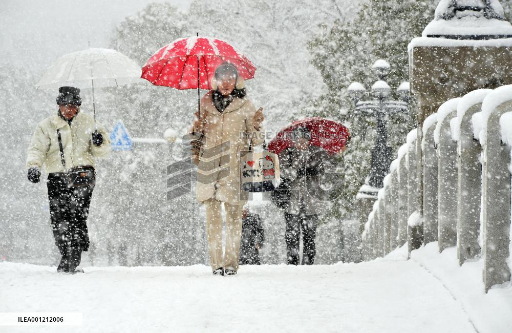 People walk under heavy snowfall in Hiroshima