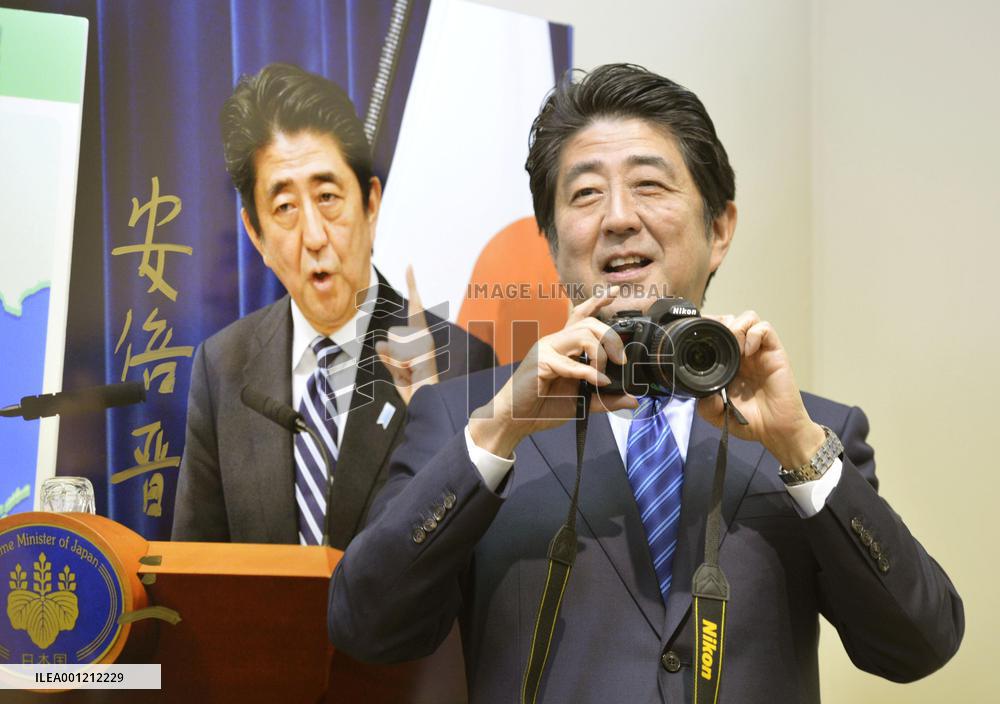 PM Abe holds camera at press photo exhibit
