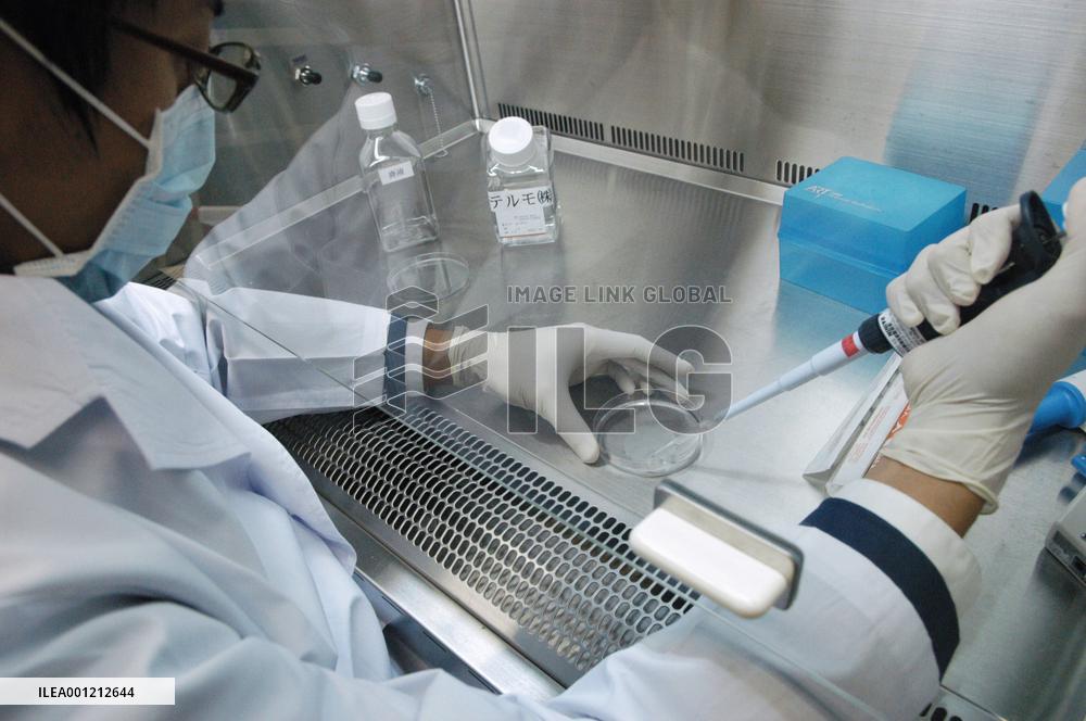 Lab worker cleanses cell sheet