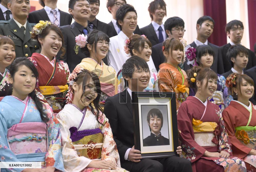 Photo of disaster victim among new adults at ceremony