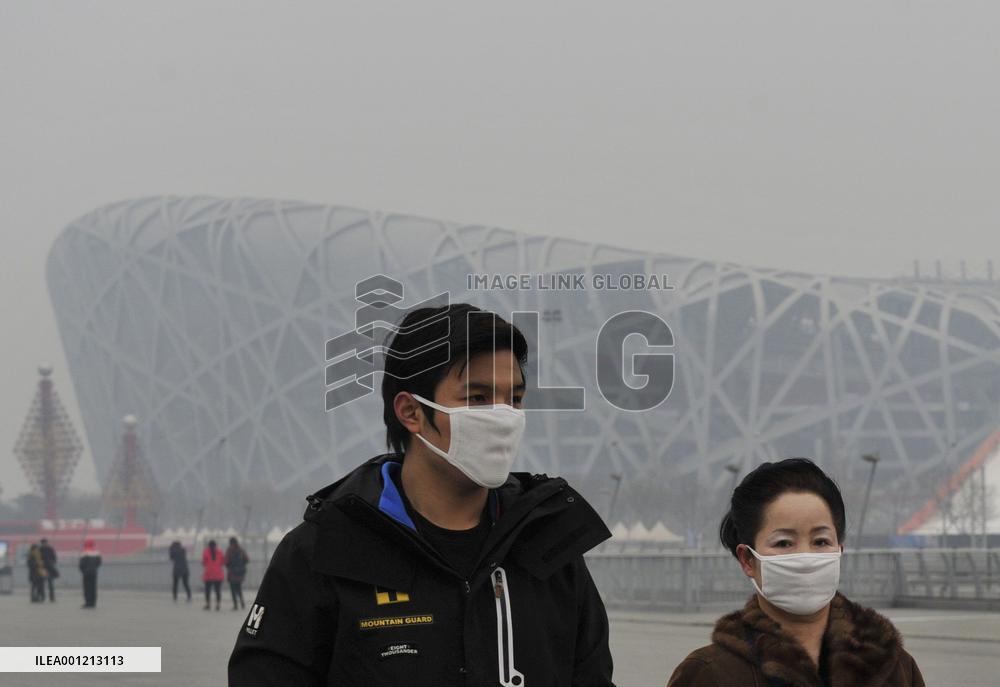 Mask-wearing citizens walk in smoggy Beijing