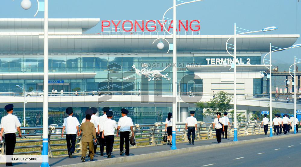 Pyongyang airport officials walk toward new terminal building