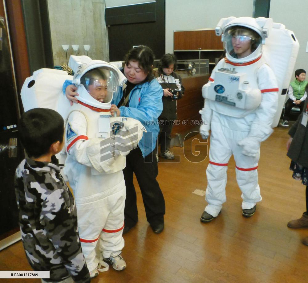 Elementary school student tries on spacesuit