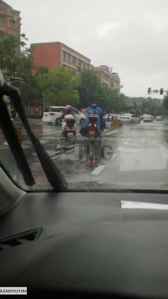 Motorcycle driver offers raincoat to unsheltered mom and daughter in SW China's Yunnan