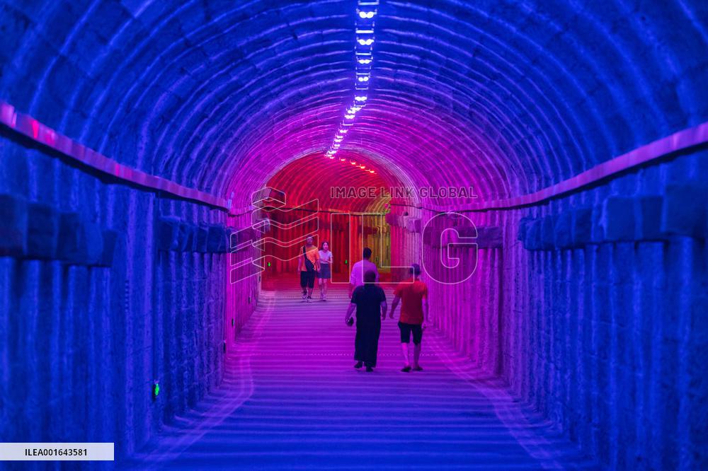 Citizens and tourists play in a converted bomb shelter in Chongqing, China, August 26, 2023. The shelter is illuminated by light