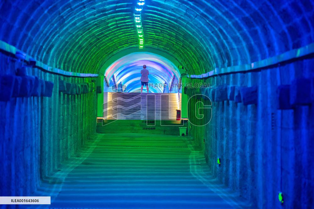 Citizens and tourists play in a converted bomb shelter in Chongqing, China, August 26, 2023. The shelter is illuminated by light