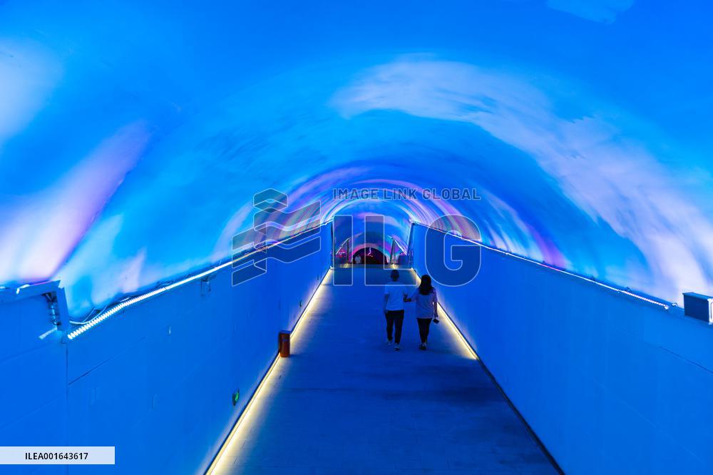 Citizens and tourists play in a converted bomb shelter in Chongqing, China, August 26, 2023. The shelter is illuminated by light