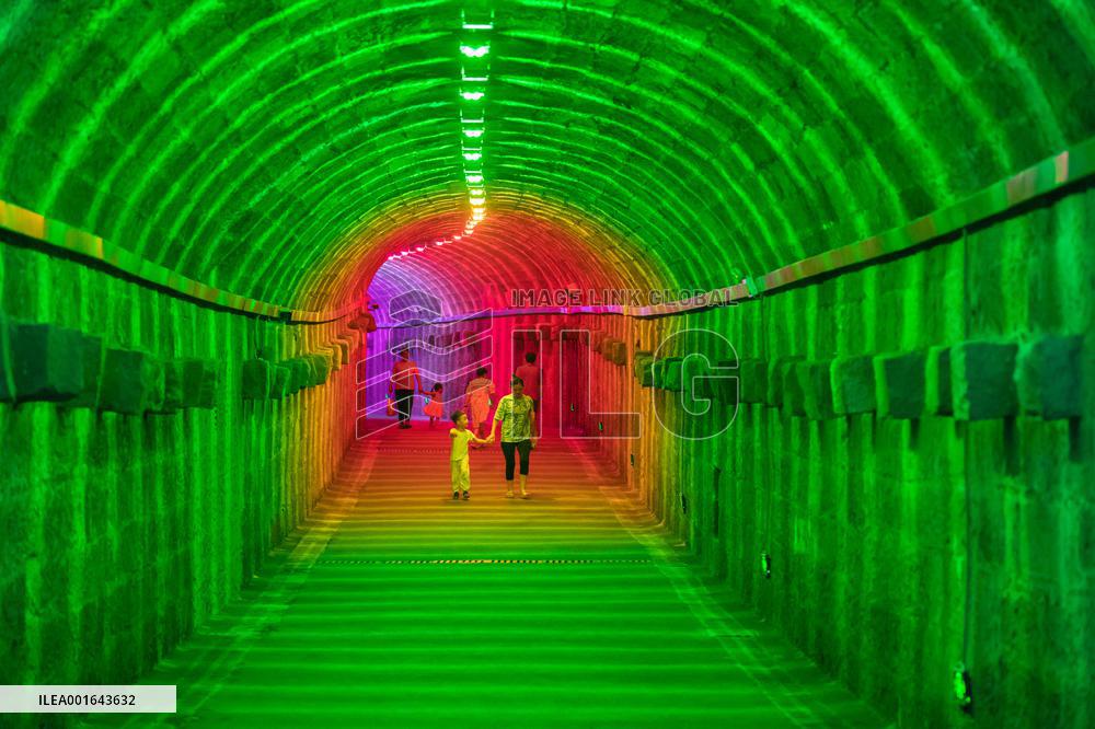 Citizens and tourists play in a converted bomb shelter in Chongqing, China, August 26, 2023. The shelter is illuminated by light