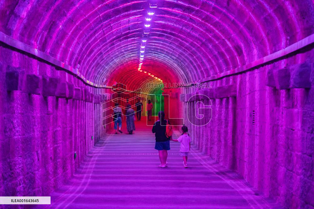 Citizens and tourists play in a converted bomb shelter in Chongqing, China, August 26, 2023. The shelter is illuminated by light