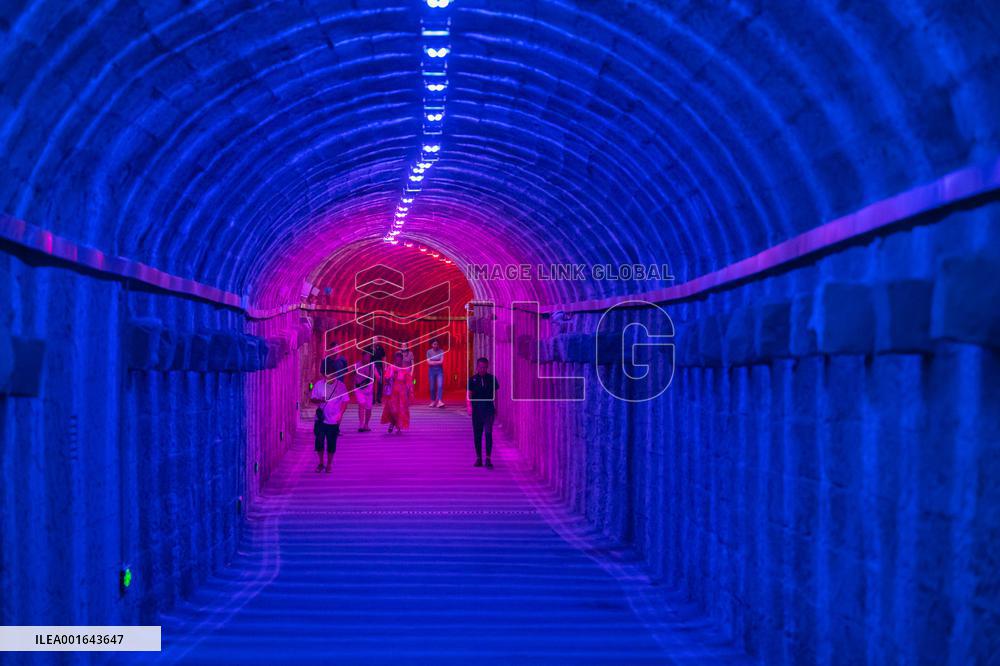 Citizens and tourists play in a converted bomb shelter in Chongqing, China, August 26, 2023. The shelter is illuminated by light