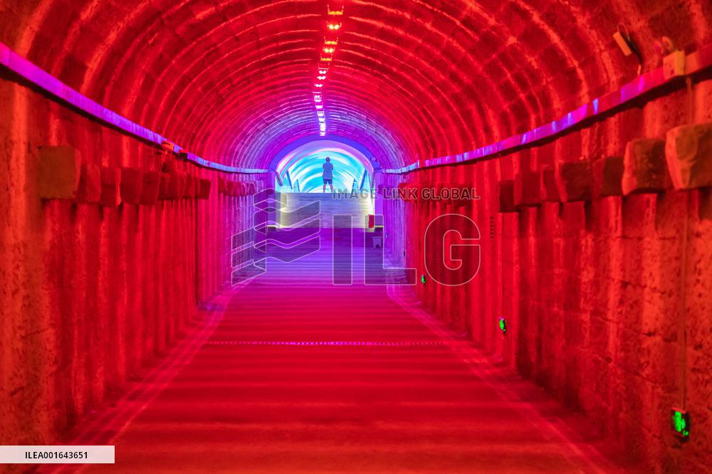 Citizens and tourists play in a converted bomb shelter in Chongqing, China, August 26, 2023. The shelter is illuminated by light