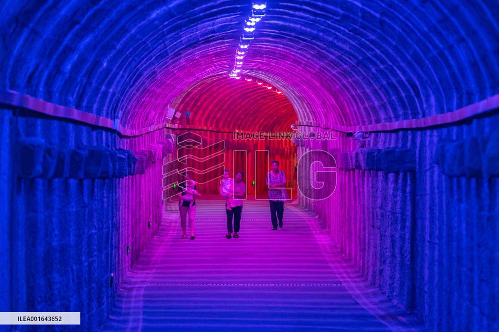 Citizens and tourists play in a converted bomb shelter in Chongqing, China, August 26, 2023. The shelter is illuminated by light