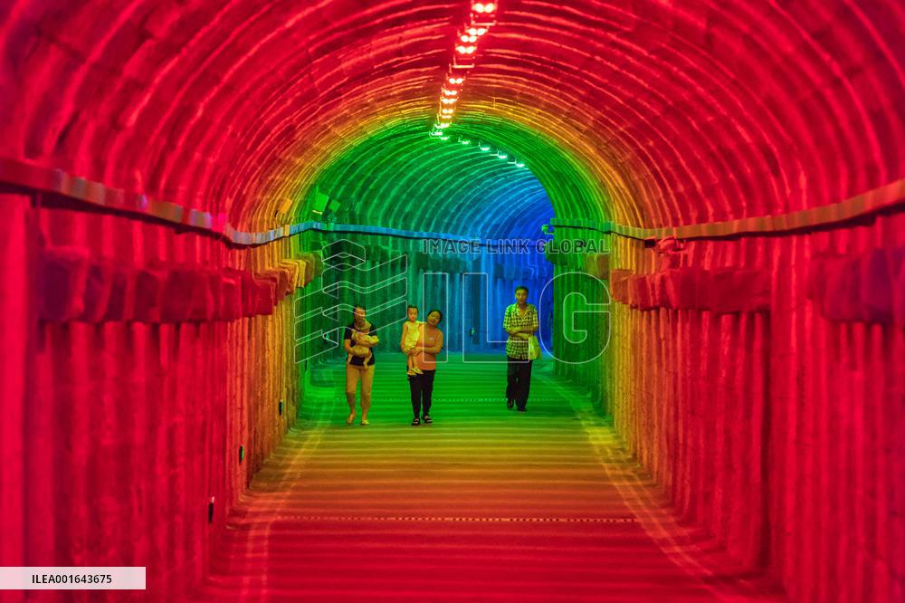 Citizens and tourists play in a converted bomb shelter in Chongqing, China, August 26, 2023. The shelter is illuminated by light