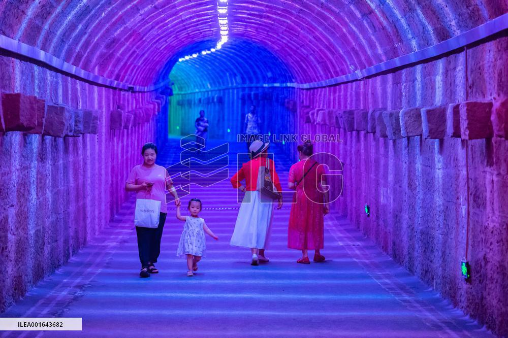 Citizens and tourists play in a converted bomb shelter in Chongqing, China, August 26, 2023. The shelter is illuminated by light