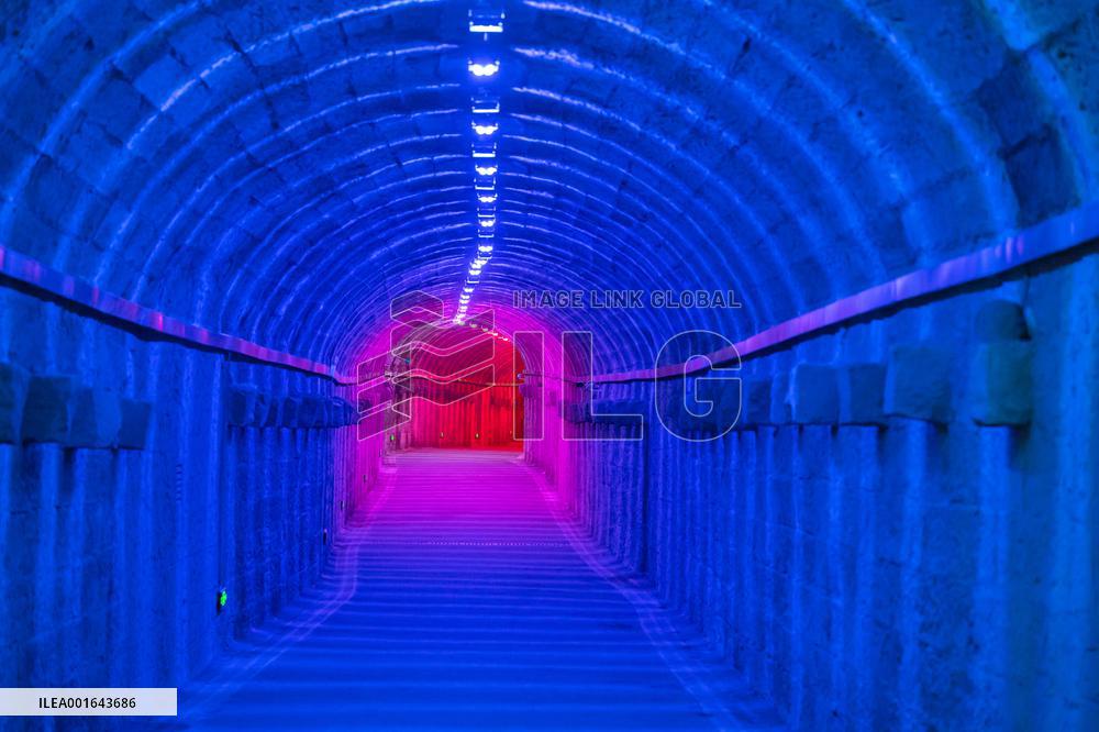 Citizens and tourists play in a converted bomb shelter in Chongqing, China, August 26, 2023. The shelter is illuminated by light