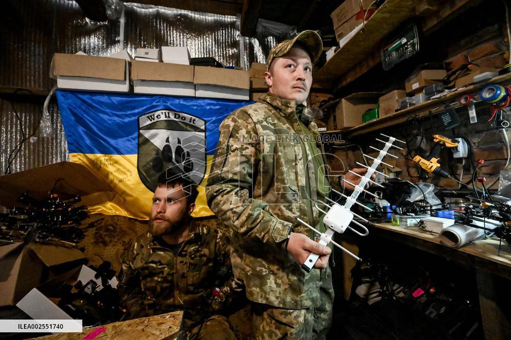 Ukrainian combat drone company soldiers configure FPV drones