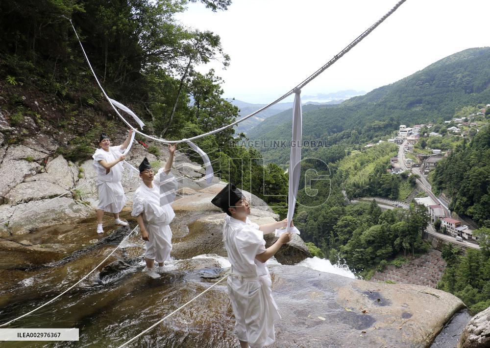 Sacred rope replace at western Japan waterfall