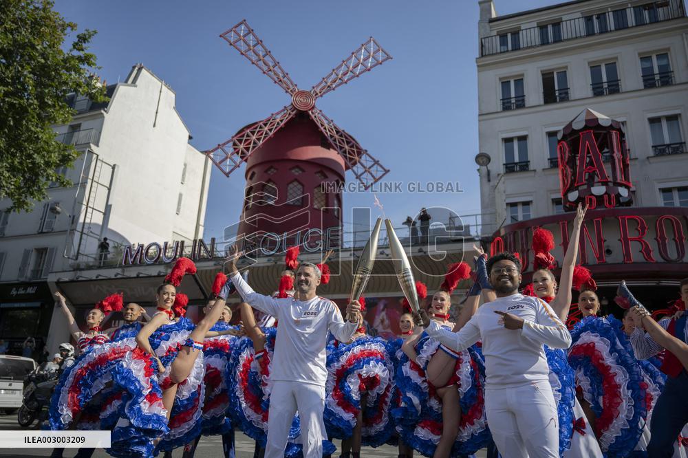 Paris 2024 - The Olympic Flame Stops By The Moulin Rouge