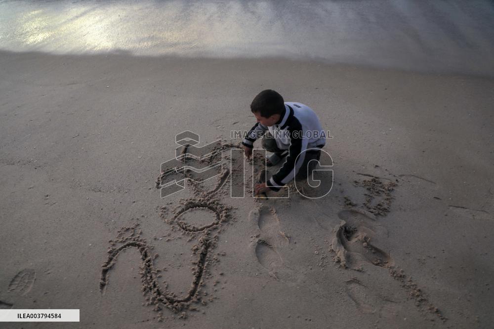 A Palestinian Boy Writes 2025 at A Beach - Gaza