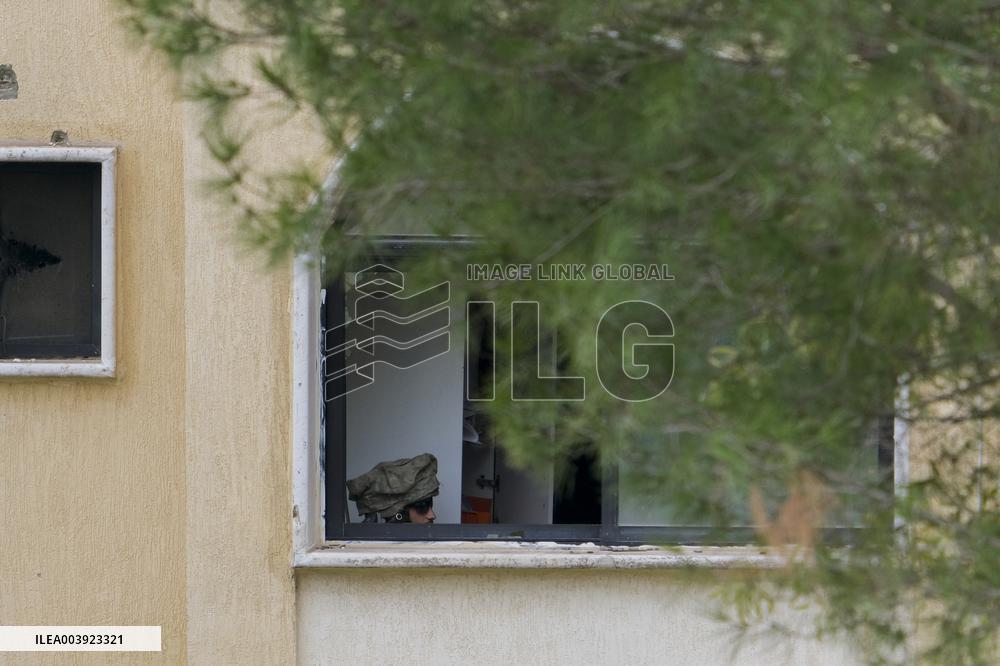 Israeli Soldiers Gather Behind Rubble In A Southern Lebanese Village