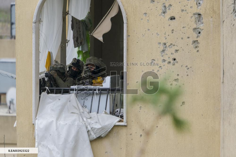 Israeli Soldiers Gather Behind Rubble In A Southern Lebanese Village