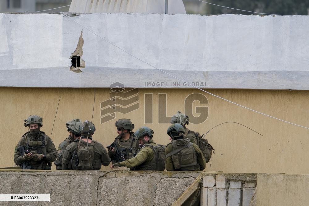 Israeli Soldiers Gather Behind Rubble In A Southern Lebanese Village