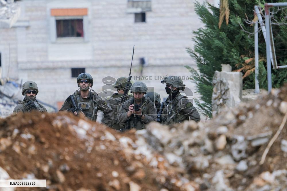 Israeli Soldiers Gather Behind Rubble In A Southern Lebanese Village