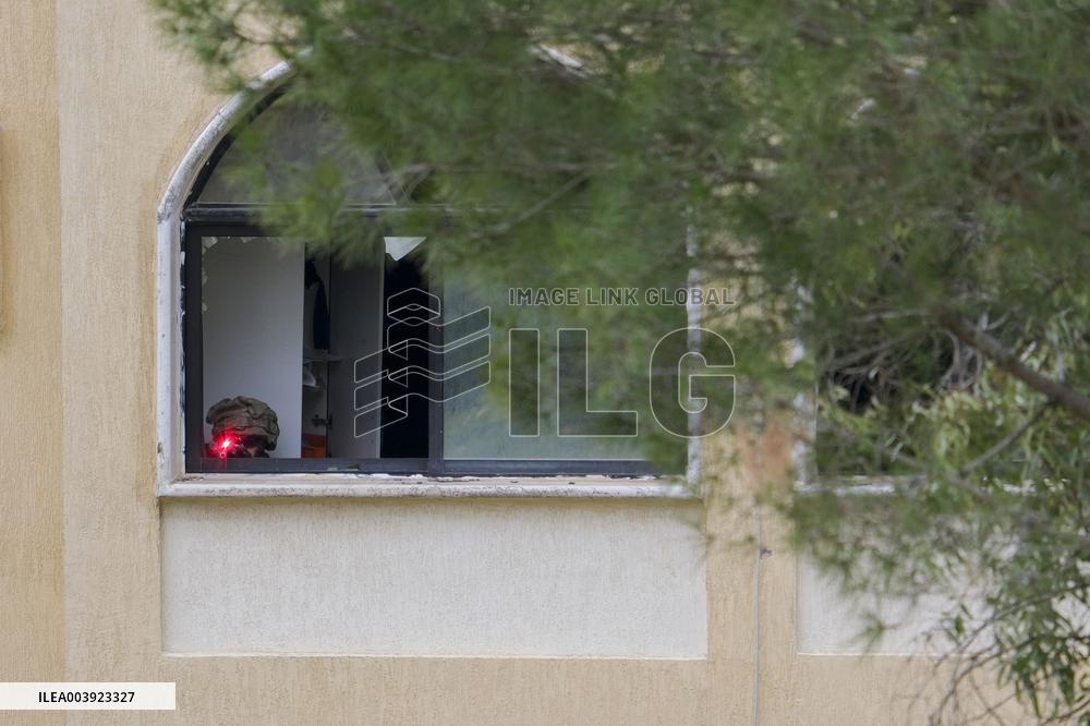 Israeli Soldiers Gather Behind Rubble In A Southern Lebanese Village