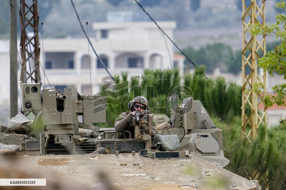 Israeli Soldiers Gather Behind Rubble In A Southern Lebanese Village