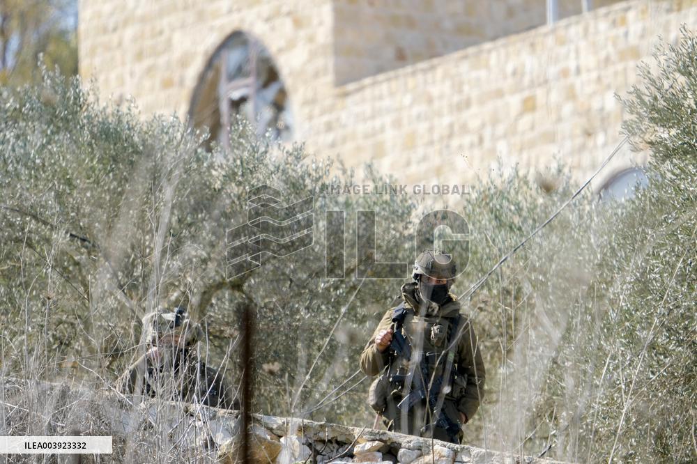 Israeli Soldiers Gather Behind Rubble In A Southern Lebanese Village