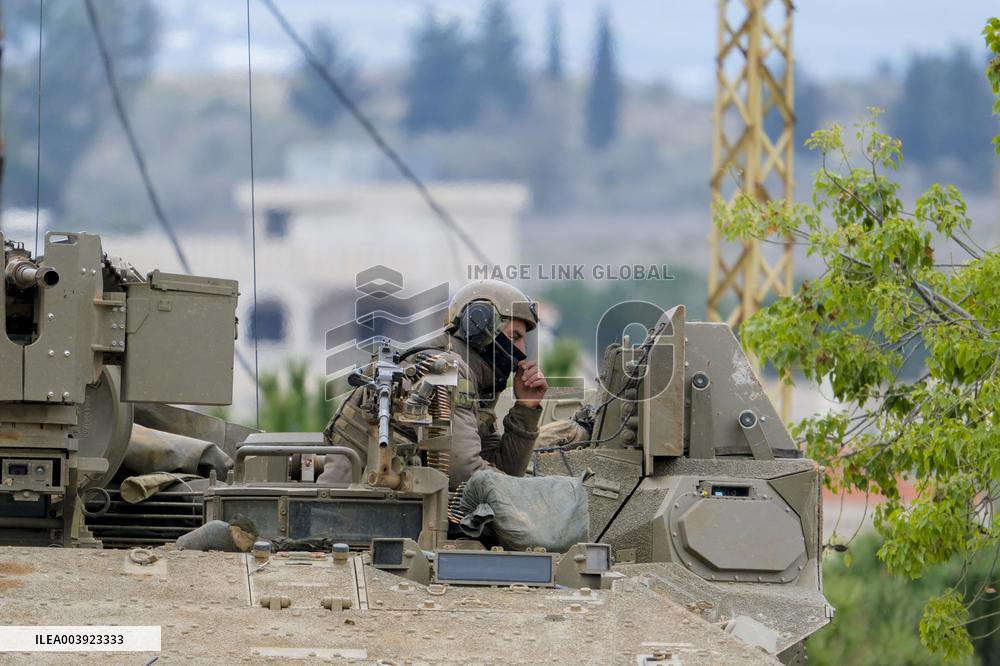 Israeli Soldiers Gather Behind Rubble In A Southern Lebanese Village