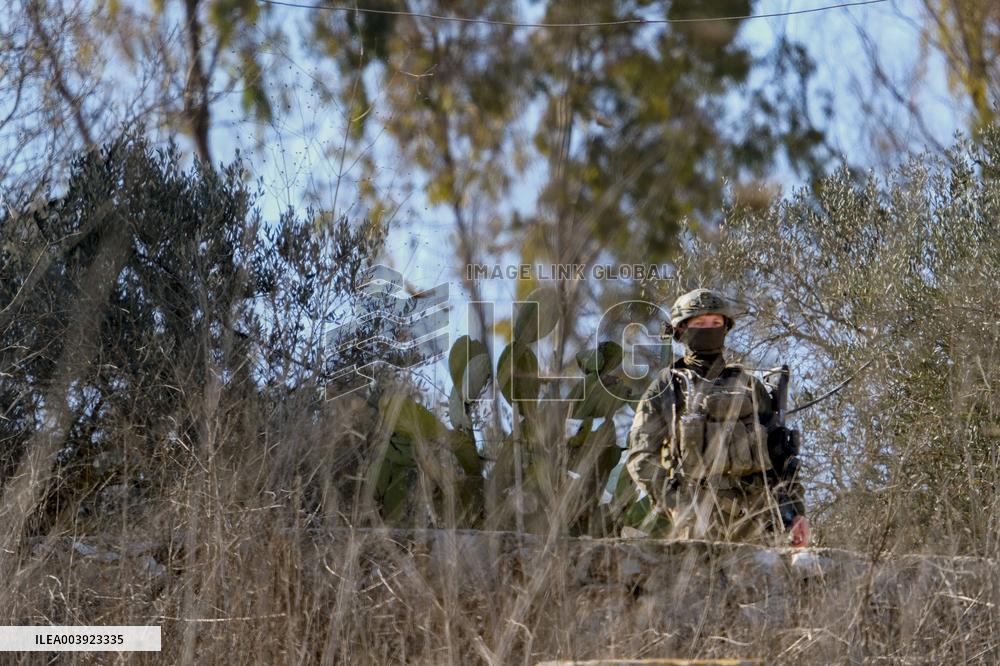 Israeli Soldiers Gather Behind Rubble In A Southern Lebanese Village