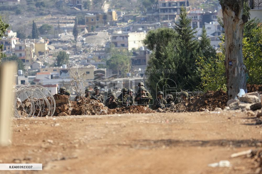 Israeli Soldiers Gather Behind Rubble In A Southern Lebanese Village