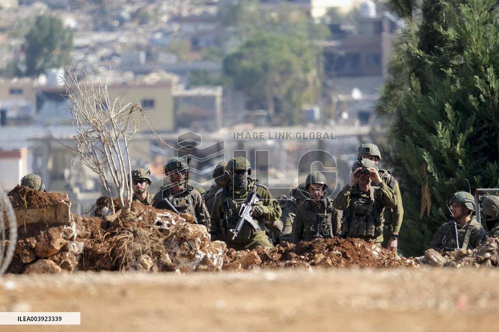 Israeli Soldiers Gather Behind Rubble In A Southern Lebanese Village