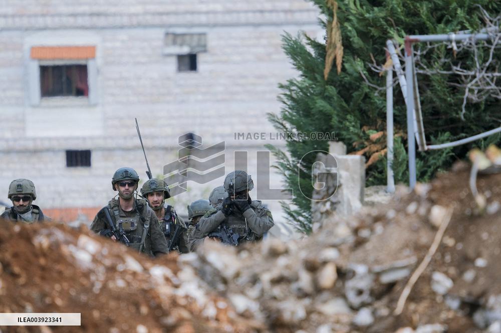 Israeli Soldiers Gather Behind Rubble In A Southern Lebanese Village