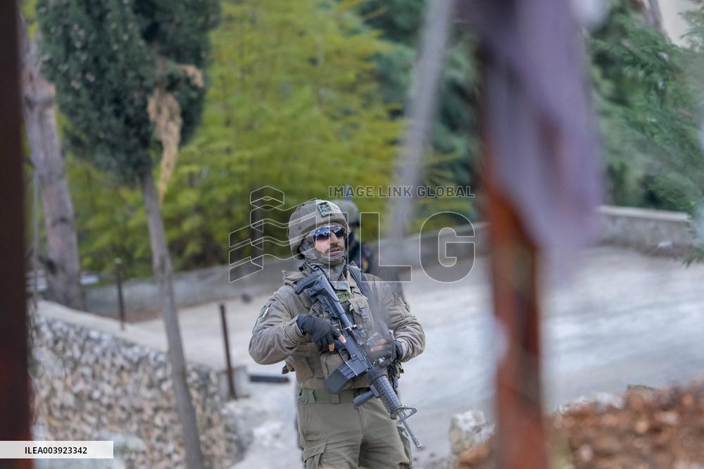 Israeli Soldiers Gather Behind Rubble In A Southern Lebanese Village
