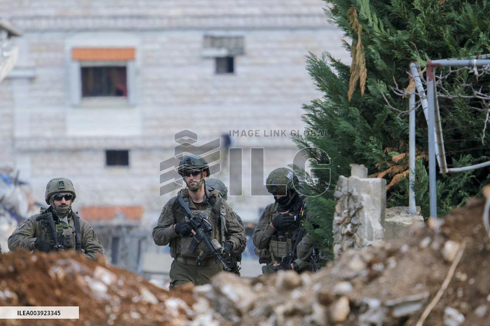 Israeli Soldiers Gather Behind Rubble In A Southern Lebanese Village
