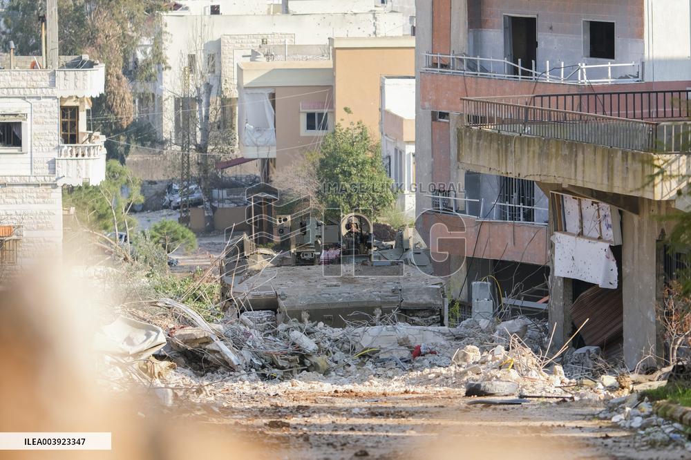 Israeli Soldiers Gather Behind Rubble In A Southern Lebanese Village