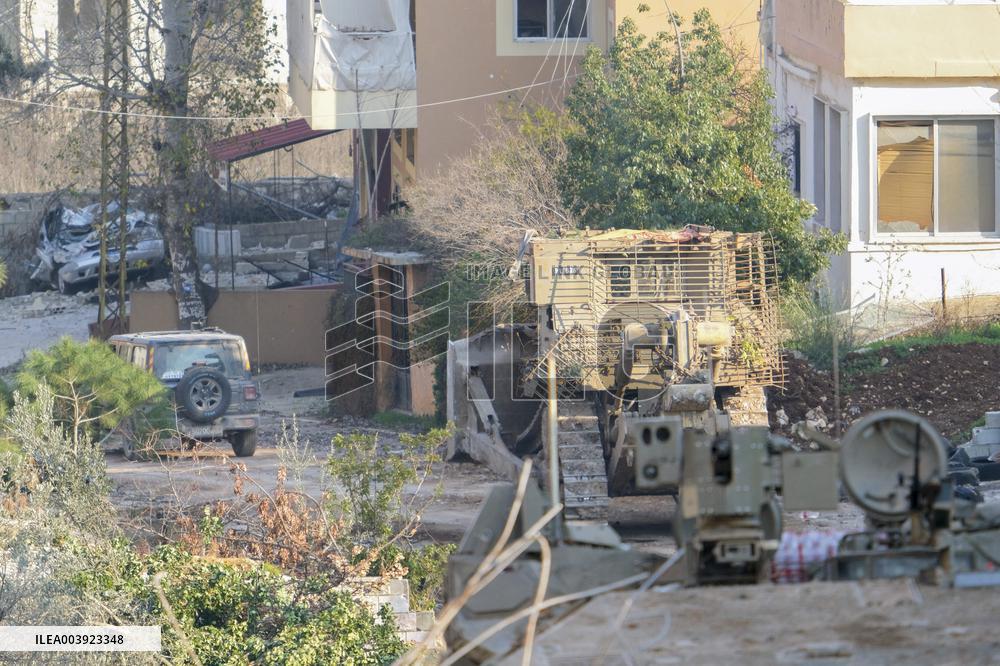 Israeli Soldiers Gather Behind Rubble In A Southern Lebanese Village