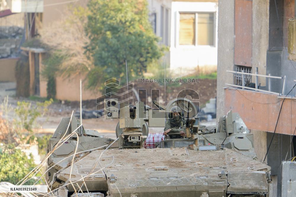 Israeli Soldiers Gather Behind Rubble In A Southern Lebanese Village