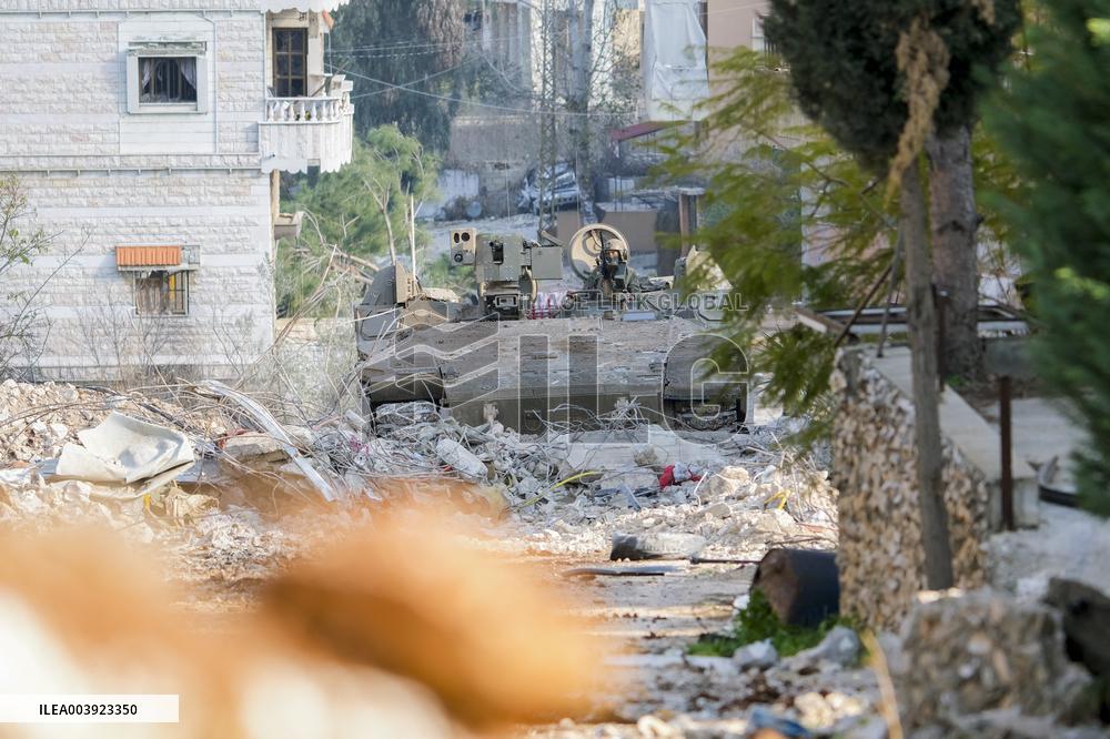 Israeli Soldiers Gather Behind Rubble In A Southern Lebanese Village