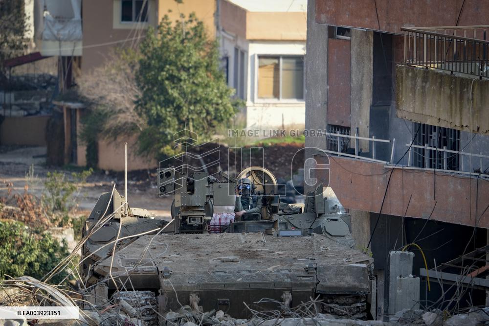 Israeli Soldiers Gather Behind Rubble In A Southern Lebanese Village