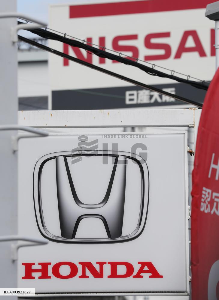 Signs and logos of Honda Motor Co. and Nissan Motor Co.