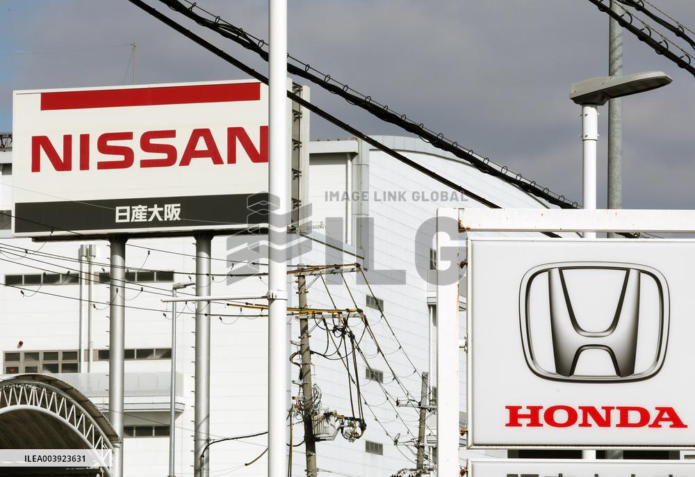Signs and logos of Honda Motor Co. and Nissan Motor Co.