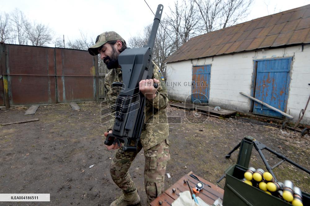 Serviceman of 57th Separate Motorized Brigade maintains American MK-19 grenade launcher