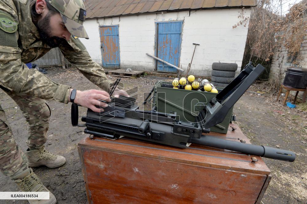 Serviceman of 57th Separate Motorized Brigade maintains American MK-19 grenade launcher
