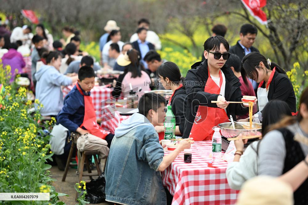 Tourists Eat Hot Pot Among Blooming Rapeseed Flowers in Nanjing